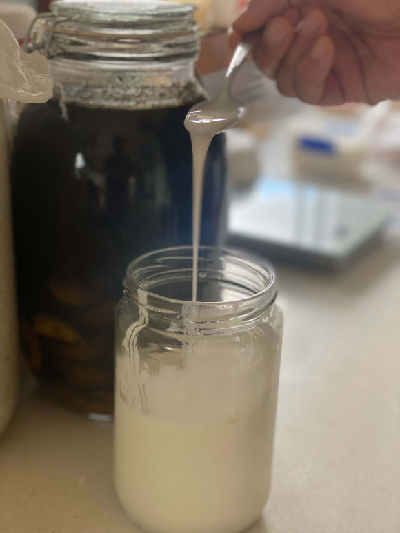 viili dripping down from spoon into jar in a long string.