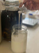 viili dripping down from spoon into jar in a long string.